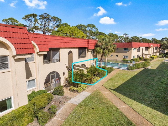 view of community with a pool and a lawn