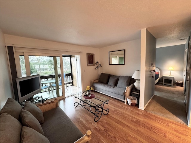 living room featuring a textured ceiling and light wood-type flooring