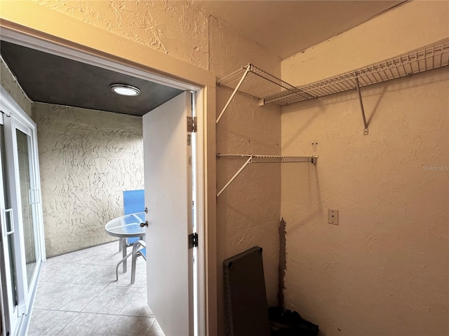 clothes washing area with tile patterned floors