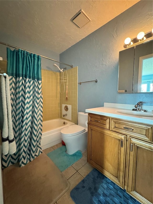 full bathroom featuring tile patterned floors, a textured ceiling, vanity, shower / tub combo with curtain, and toilet