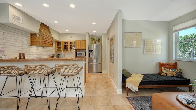 kitchen with sink, a kitchen breakfast bar, tasteful backsplash, kitchen peninsula, and appliances with stainless steel finishes