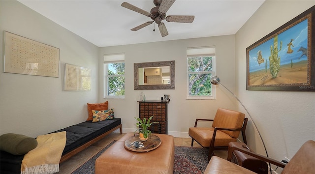 living area with tile patterned floors, ceiling fan, and a healthy amount of sunlight