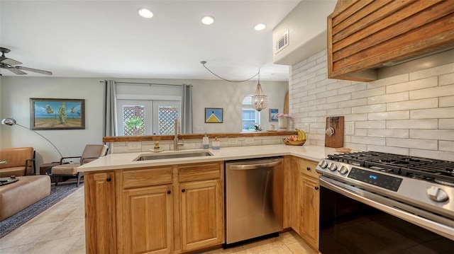 kitchen featuring kitchen peninsula, tasteful backsplash, stainless steel appliances, sink, and hanging light fixtures