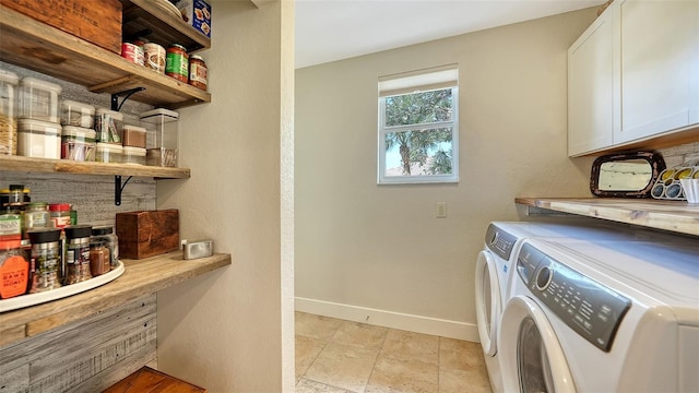 clothes washing area featuring cabinets and independent washer and dryer