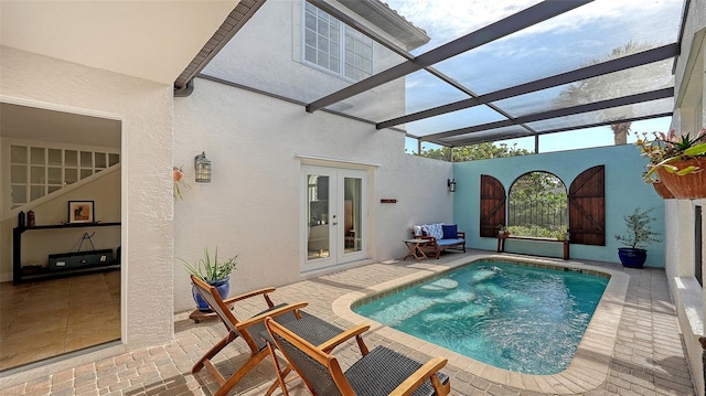 view of pool featuring french doors, a patio, and glass enclosure