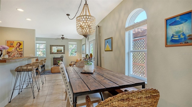 dining room featuring light tile patterned floors and ceiling fan with notable chandelier