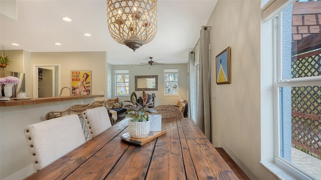 dining area featuring ceiling fan with notable chandelier