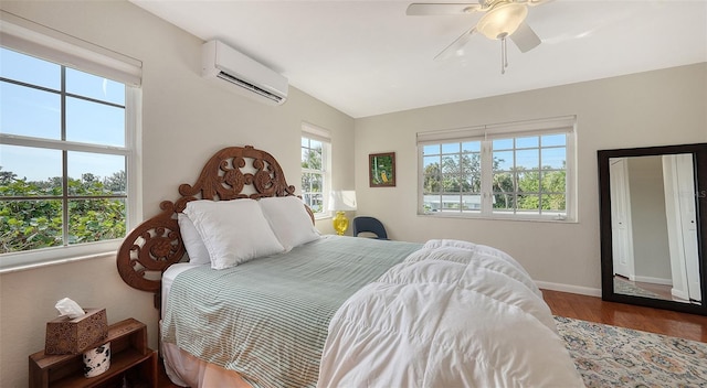 bedroom with a wall mounted air conditioner, ceiling fan, hardwood / wood-style floors, and multiple windows