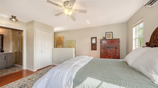 bedroom featuring hardwood / wood-style floors, a closet, an AC wall unit, and ceiling fan