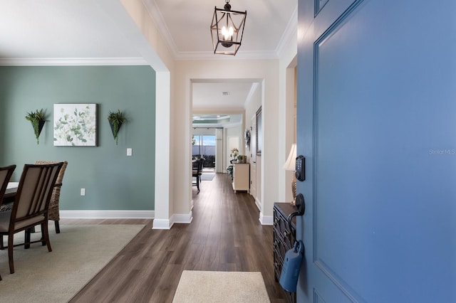 entryway featuring a chandelier, dark hardwood / wood-style floors, and crown molding