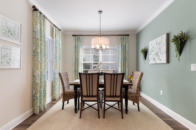 dining room with crown molding, dark hardwood / wood-style flooring, and a chandelier