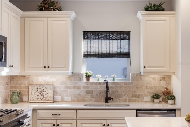 kitchen featuring tasteful backsplash, sink, white cabinets, and stainless steel appliances