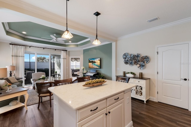 kitchen featuring ceiling fan, dark hardwood / wood-style flooring, hanging light fixtures, and ornamental molding