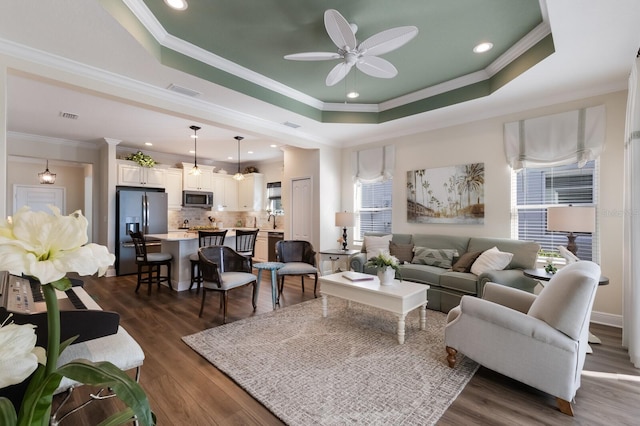 living room featuring a wealth of natural light, crown molding, and dark wood-type flooring