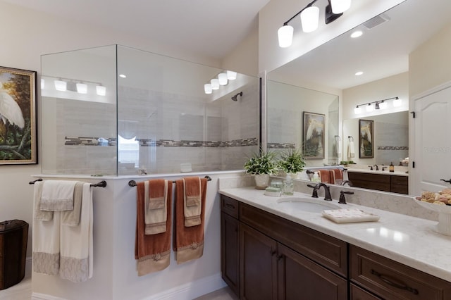 bathroom featuring a tile shower and vanity