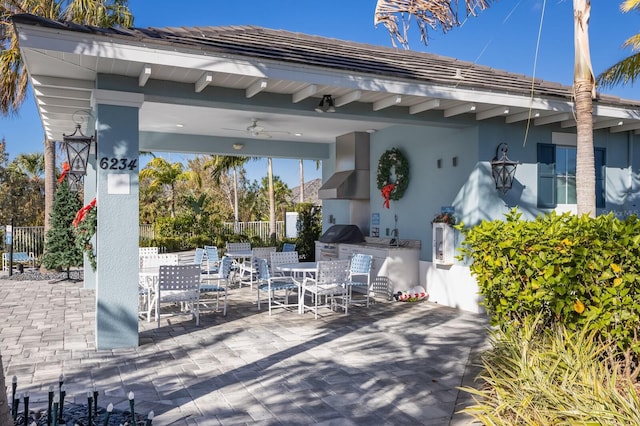 view of patio / terrace featuring ceiling fan, area for grilling, and an outdoor kitchen