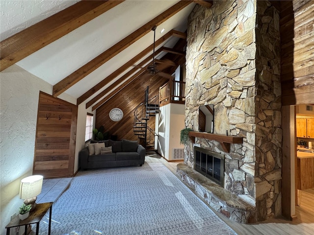 unfurnished living room with beamed ceiling, a stone fireplace, and high vaulted ceiling