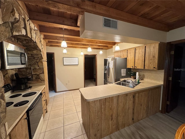 kitchen featuring kitchen peninsula, hanging light fixtures, beamed ceiling, and stainless steel appliances