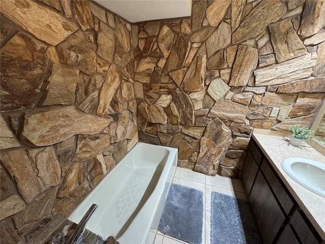 bathroom featuring tile patterned floors, a tub to relax in, and vanity