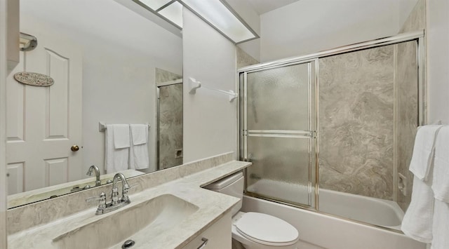 full bathroom featuring vanity, toilet, and bath / shower combo with glass door