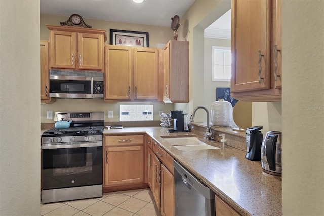 kitchen featuring sink, light tile patterned floors, stainless steel appliances, and ornamental molding