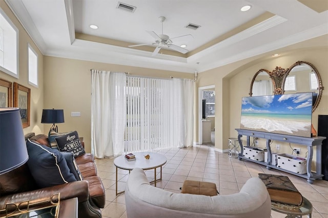 living room with ceiling fan, light tile patterned floors, and a tray ceiling