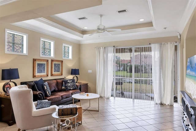 living room featuring light tile patterned floors, a raised ceiling, ceiling fan, and crown molding