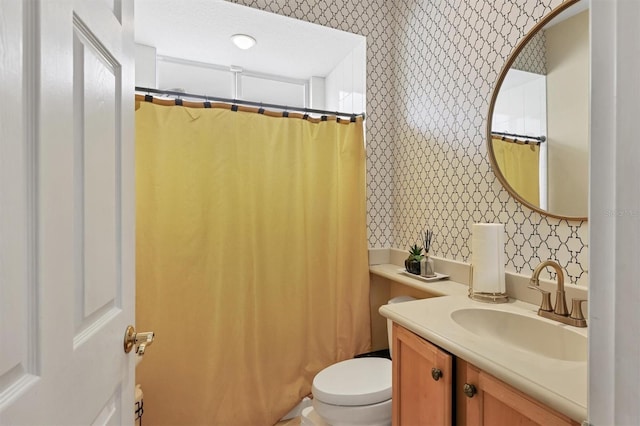 bathroom featuring a shower with shower curtain, vanity, and toilet