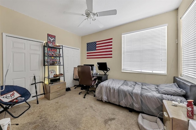 carpeted bedroom featuring ceiling fan and multiple windows