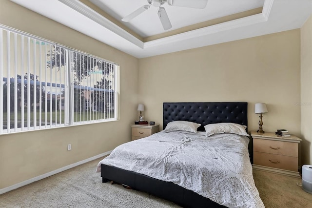 carpeted bedroom featuring ceiling fan and a raised ceiling