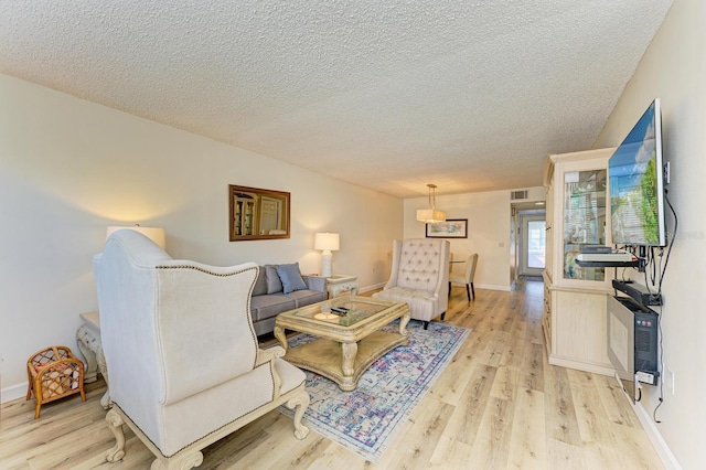 living room with light hardwood / wood-style floors and a textured ceiling