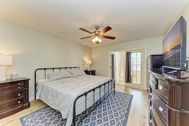 bedroom with ceiling fan, light hardwood / wood-style floors, and a textured ceiling