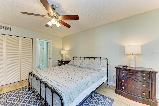 bedroom featuring ceiling fan, light hardwood / wood-style floors, a textured ceiling, and a closet