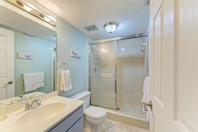 bathroom featuring toilet, vanity, tile patterned floors, and walk in shower