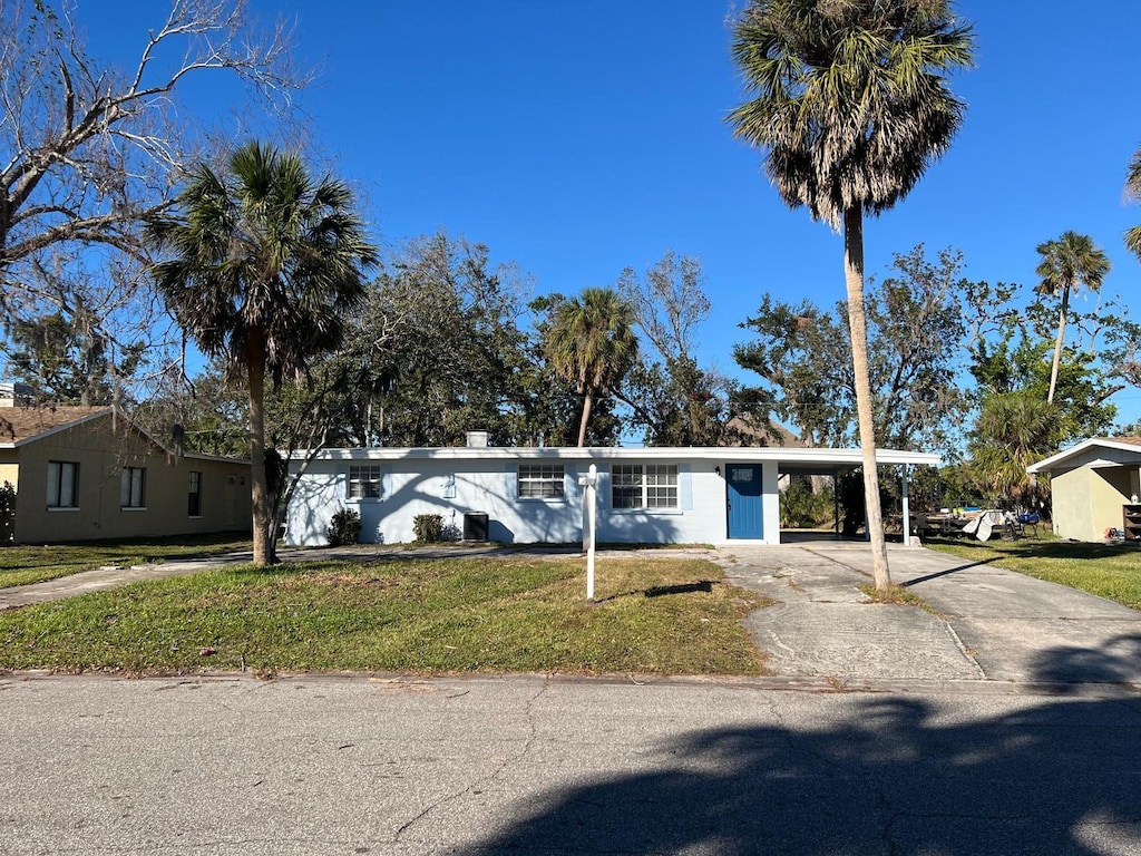 single story home with a front yard and a carport