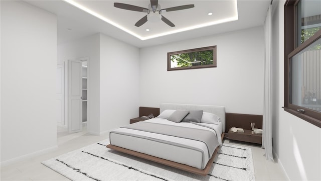 bedroom with a tray ceiling, multiple windows, and ceiling fan