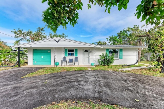 single story home with covered porch and a garage