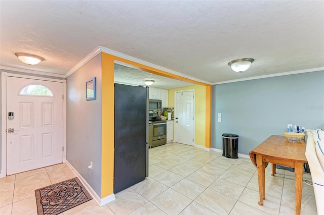 kitchen with white cabinets, decorative backsplash, ornamental molding, a textured ceiling, and appliances with stainless steel finishes