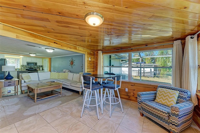 interior space with wood walls, light tile patterned flooring, and wooden ceiling