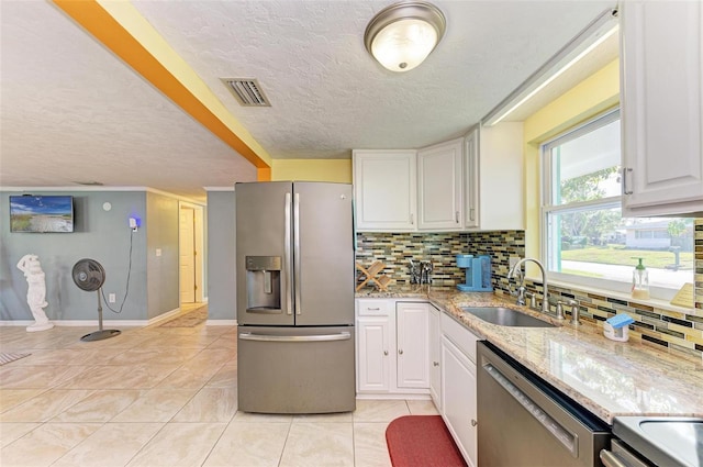 kitchen featuring white cabinets, sink, light tile patterned floors, light stone countertops, and appliances with stainless steel finishes