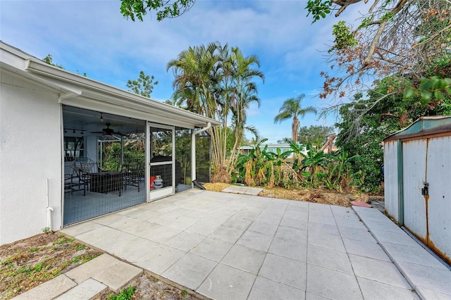 view of patio with ceiling fan and a shed