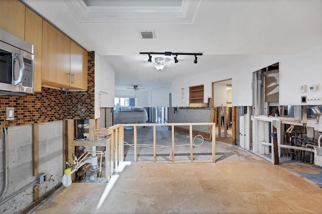 kitchen with decorative backsplash, ceiling fan, and ornamental molding