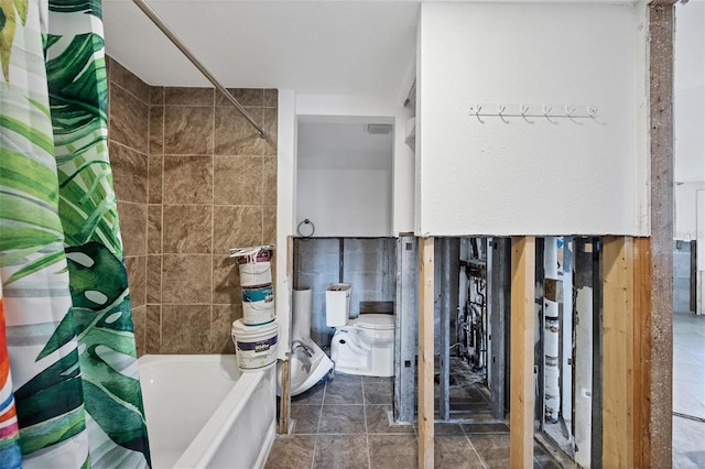 bathroom with tile patterned floors, shower / bath combination with curtain, tile walls, and toilet