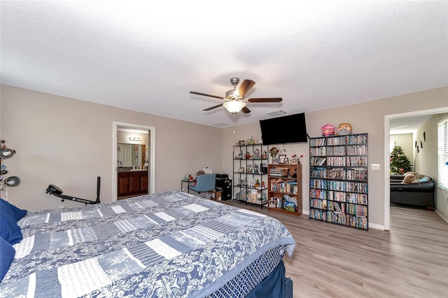 bedroom featuring connected bathroom, a textured ceiling, ceiling fan, and light wood-type flooring