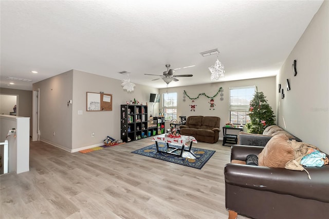 living room featuring ceiling fan and light hardwood / wood-style flooring