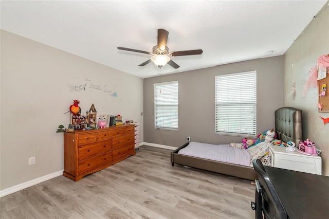 bedroom with ceiling fan and light hardwood / wood-style flooring