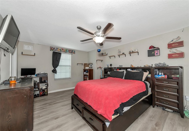 bedroom featuring a textured ceiling, ceiling fan, and light hardwood / wood-style flooring