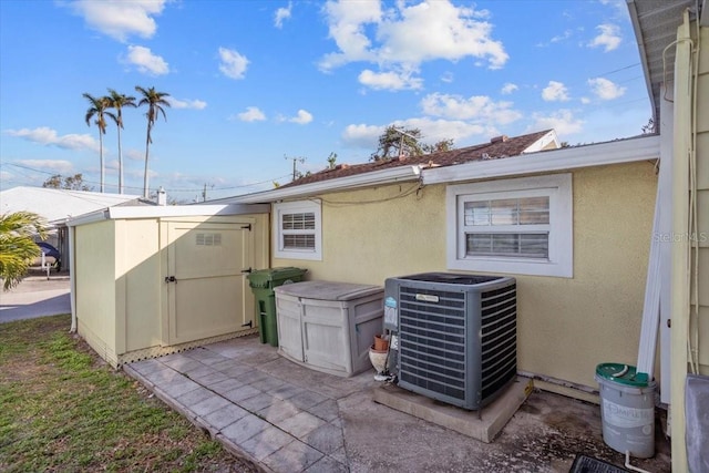 exterior space with cooling unit and a storage shed