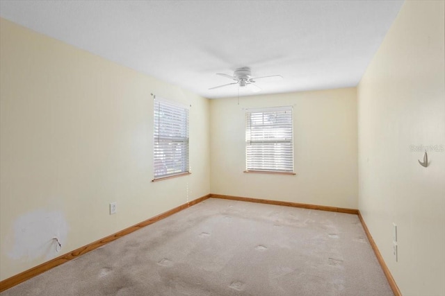 carpeted spare room featuring ceiling fan