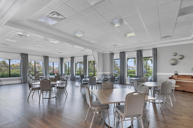 dining space featuring a paneled ceiling and dark wood-type flooring